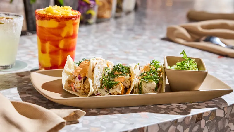 a plate of tacos and a margarita on a table