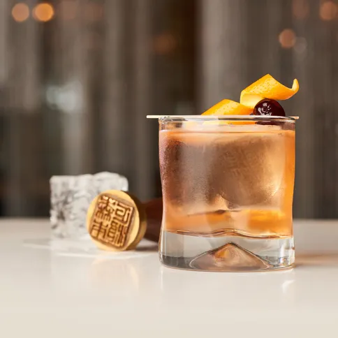 a cocktail in a glass garnished with fruit