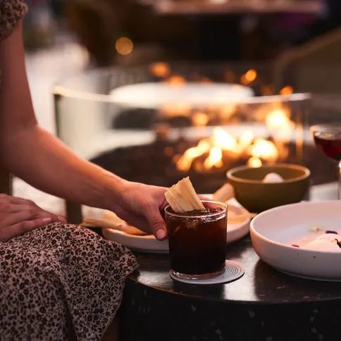 a person sitting at a table with food and drinks