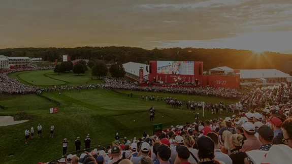 Crowd watching golf event at sunset