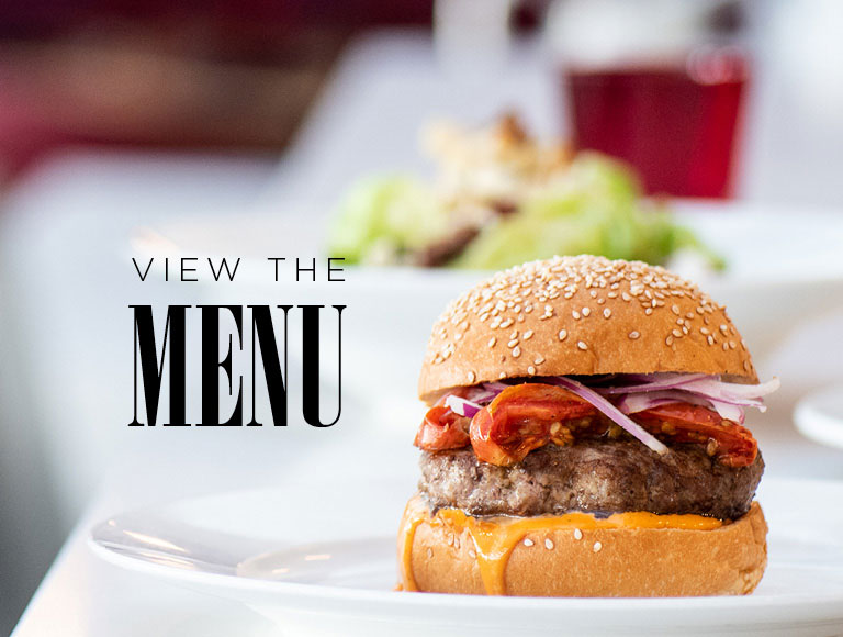 View the Menu | Featuring a hamburger dinner with drink. 