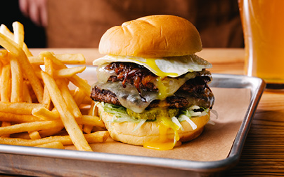 Burger served with an egg and French fries