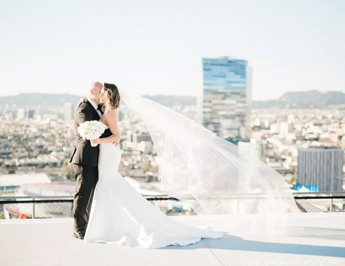 Bride and groom embrace on top of South Park Center in downtown Los Angeles